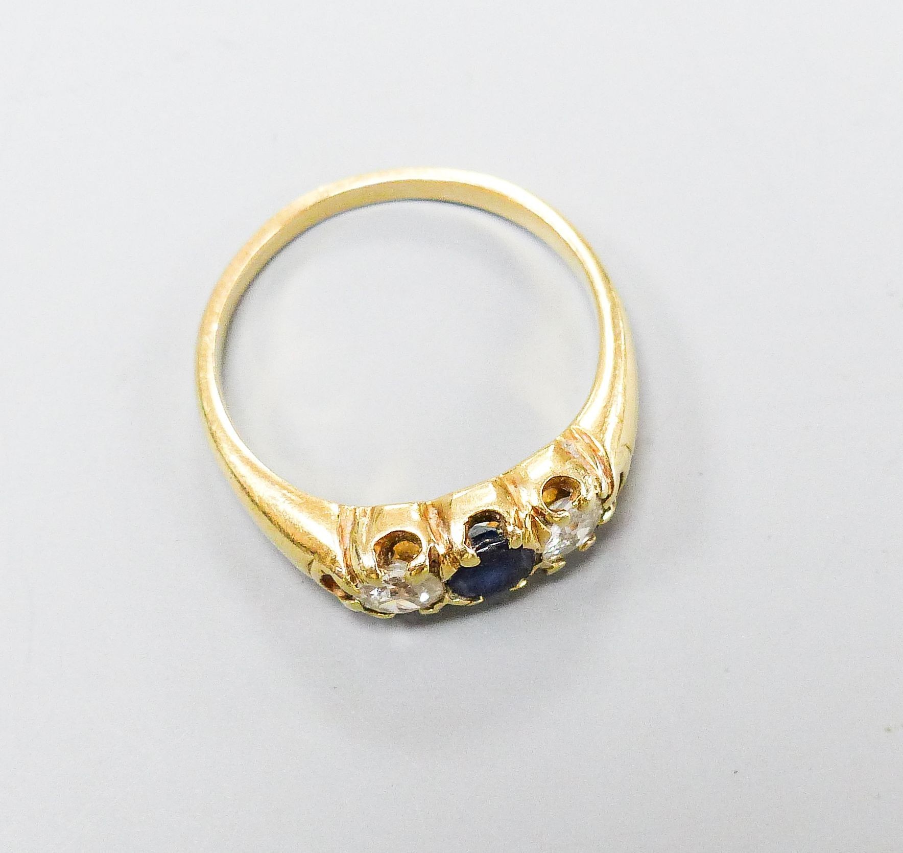 A yellow metal, sapphire and diamond set three stone ring, size S, gross weight 5.6 grams.